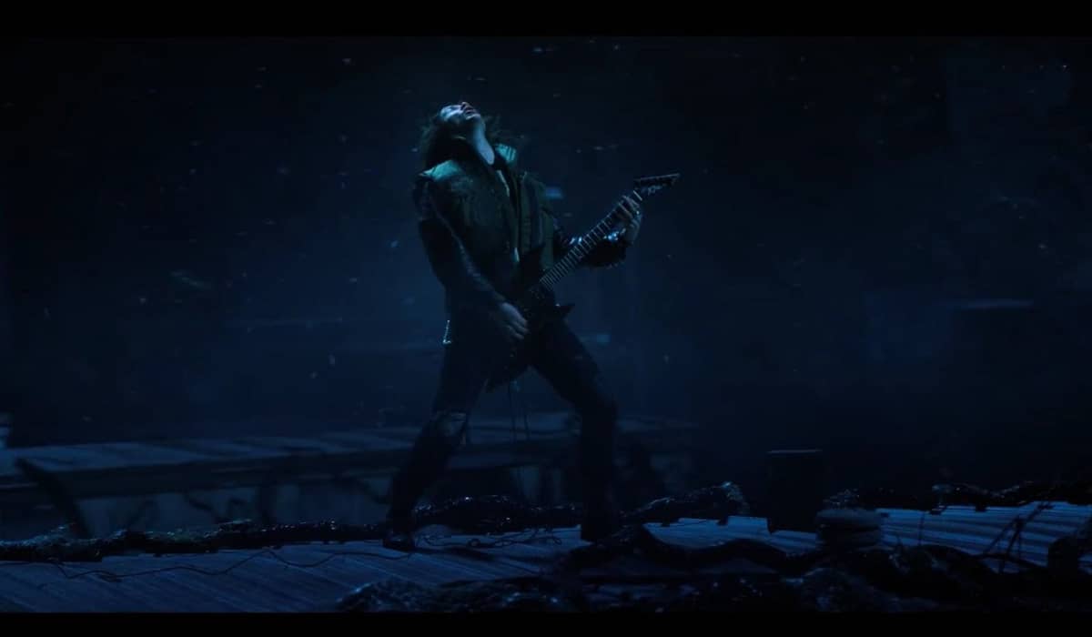 Na cena, Eddie toca para salvar amigos dos demo bats. Fonte: Reprodução/Netflix
